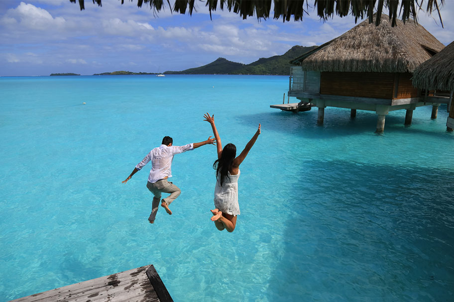 Flitterwochen Französisch Polynesien Paar Wasser Paar springt von Bungalow in Wasser Honeymoon Polynesien